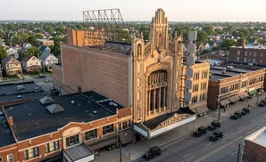 An aerial view of the historic Uptown Theater and surrounding buildings, with classic cars parked along the street.