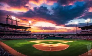 A baseball stadium at sunset with a vibrant sky and illuminated field.