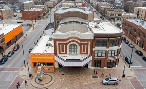Aerial view of a city street with a historic theater, orange building, and cars.