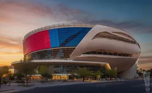 Modern stadium with a colorful LED facade and curved, metallic exterior at sunset.