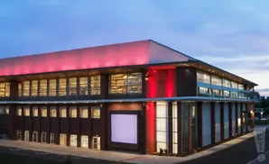 Modern building with red uplighting on a clear evening.