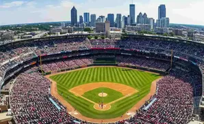 Aerial view of a baseball stadium filled with fans, with a cityscape in the background.
