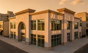 Modern commercial building with large windows at sunset.