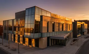 Modern building with glass facade reflects sunset.
