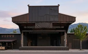 An outdoor amphitheater stage with mountains in the background at sunset.