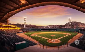 Baseball stadium with a towering skyscraper on a mountain in the background at sunset.