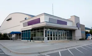 Modern arena with arched roof and glass entrance.
