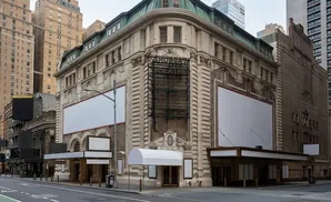Exterior view of the Shubert Theatre on a city street, with blank billboards on its facade.