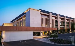 Modern building with stone facade and wood accents at dusk.