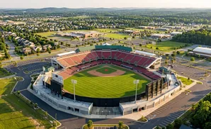 Aerial view of a baseball stadium with surrounding residential areas, businesses, and sports facilities.