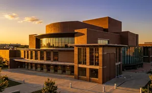 Modern brick building with large windows at sunset.