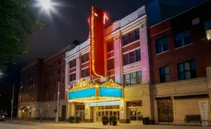 A theater at night, with a large red marquee adorned with lights.
