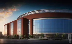 Exterior of a modern brick and glass arena with a curved, transparent roof under a dramatic sky.