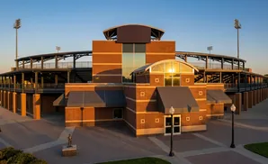 Baseball stadium with brick facade and tiered seating under a clear blue sky.