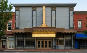 An old movie theater facade with a marquee, gold trim, and double doors.