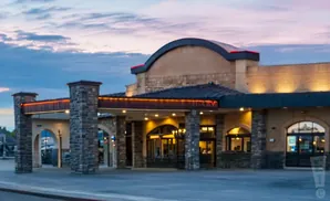 A stone-accented building with warm lighting and a curved roof at dusk.