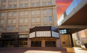 A building with a marquee and a skybridge against a sunset sky.
