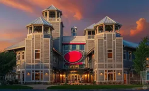 A modern building with wooden siding and towers at sunset.