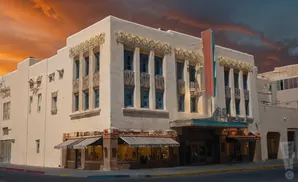 Historic theater with ornate details and a dramatic sunset sky.