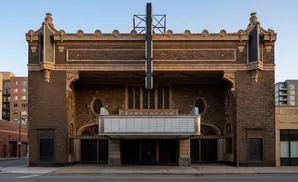 Art deco movie theater with a marquee and ornate brickwork.