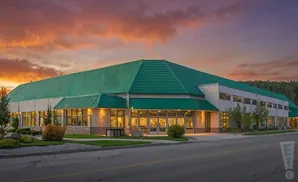A modern building with a green roof at sunset.