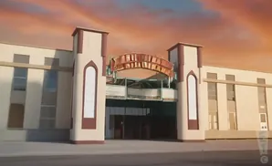 Building with tan facade, red trim, arched windows, and a sign above the entrance.