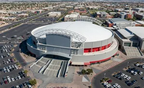 Aerial view of a large domed arena complex with surrounding parking lots and buildings.