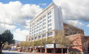 A tall, white building with a sign reading 