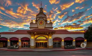 Spanish Mission-style building with a clock tower at sunset.