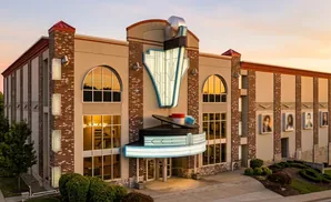 Art deco theater with a record player marquee at sunset.