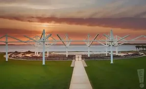 Outdoor amphitheater at sunset with a water view.
