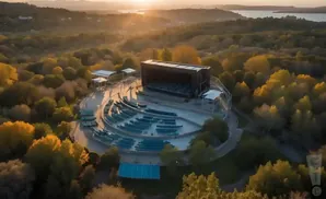 Aerial view of an outdoor amphitheater nestled among trees at sunset.
