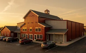 A red barn-style building with white trim under a golden sky.