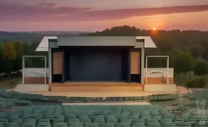 Outdoor amphitheater with stage and seating area at sunset.