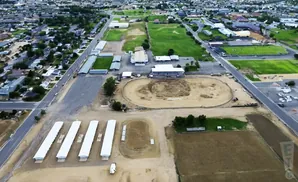 Aerial view of a fairground with livestock barns, arenas, and buildings.
