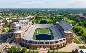 Aerial view of Memorial Stadium at the University of Nebraska–Lincoln, with a football field and surrounding campus buildings.