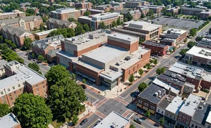 Aerial view of a university campus with brick buildings, trees, and streets.