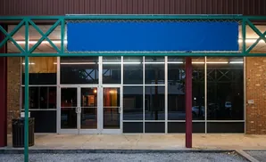 A storefront with a large blue banner above the glass entrance doors.