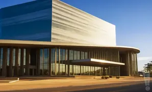 Modern building with blue and beige facade and large glass windows on a sunny day.