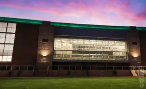 Modern building with large windows and green trim at dusk.