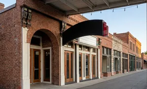 Brick buildings with marquees line a street.