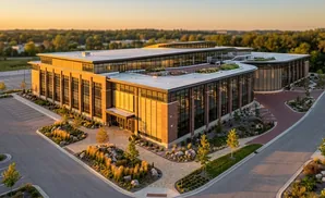 An aerial view of a modern brick and glass office building at sunset.