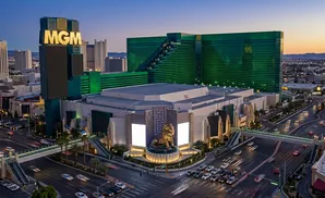 MGM Grand Las Vegas with its iconic lion statue and green buildings at dusk.