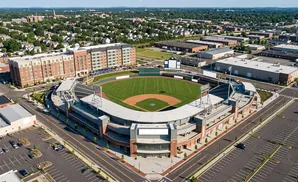 Aerial view of a baseball stadium and surrounding urban area.