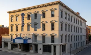 The Bijou theater building, with its ornate windows and marquee, glows in the warm afternoon sun.