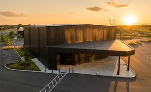 Modern industrial building with a cantilevered roof at sunset.