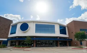 Modern brick building with a white, octagonal facade featuring large blue windows and a circular window.