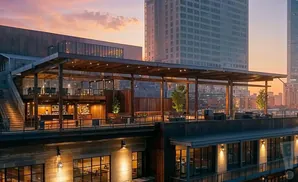 Rooftop bar and restaurant with city skyline at sunset.