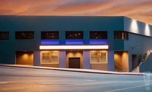 Art deco building with glowing marquee and blue neon accents at dusk.