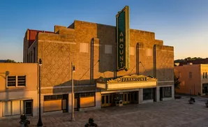 Paramount Theater with marquee and tall sign at sunset.